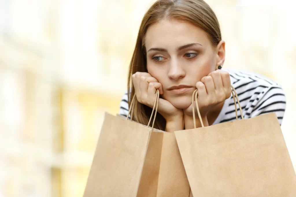 disappointed-girl-sitting-with-shopping-bags