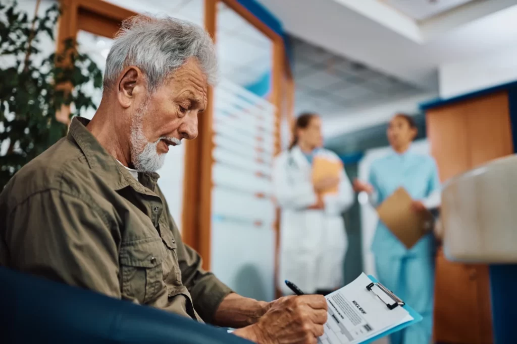 senior-man-writing-his-data-in-medical-report