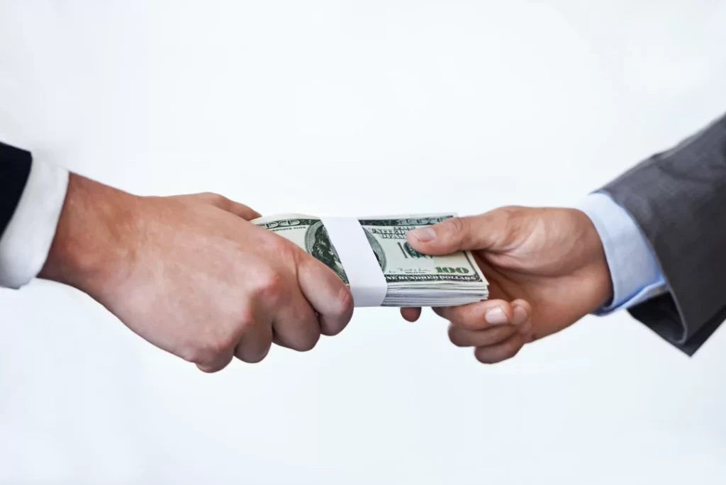 stack-of-money-being-passed-between-two-people
